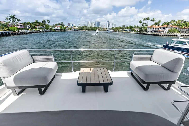 Lobster Tails Yacht Photos Pics Luxurious 2023 Absolute 52 FLY yacht deck with modern seating, overlooking scenic waterfront views.