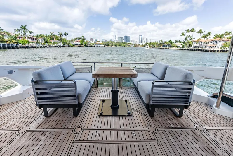 Lobster Tails Yacht Photos Pics Luxurious 2023 Absolute 52 FLY yacht deck with seating, overlooking scenic waterfront views.