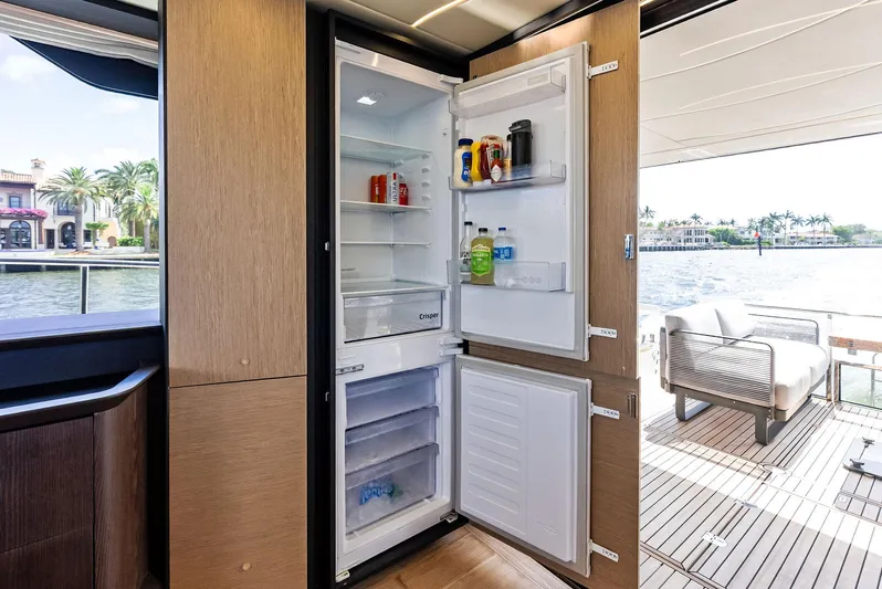 Lobster Tails Yacht Photos Pics Modern kitchen on 2023 Absolute 52 FLY yacht with open fridge, scenic water view.
