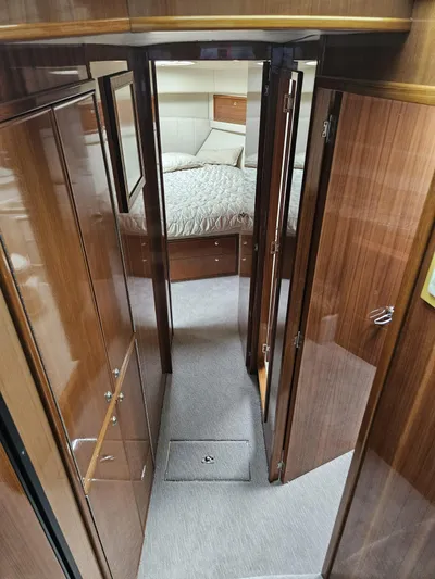  Yacht Photos Pics Interior hallway of 2007 Riviera 42 yacht, featuring wood paneling and a cozy bedroom.