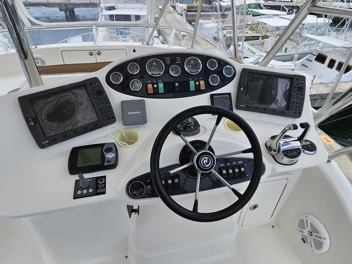  Yacht Photos Pics Control panel of a 2007 Riviera 42 yacht with navigation instruments and steering wheel.
