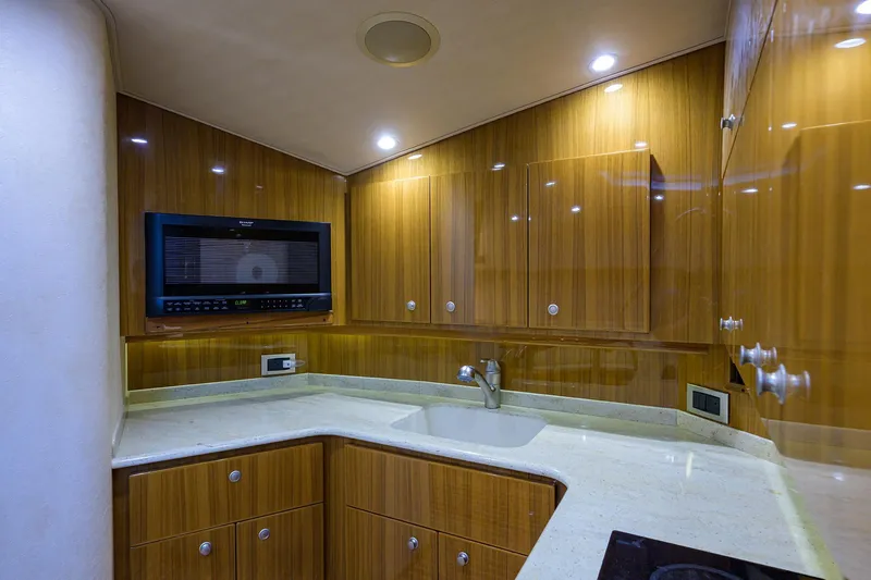 Galene Yacht Photos Pics Luxurious kitchen interior of 2013 Viking 42 Open yacht with wood cabinetry and modern appliances.
