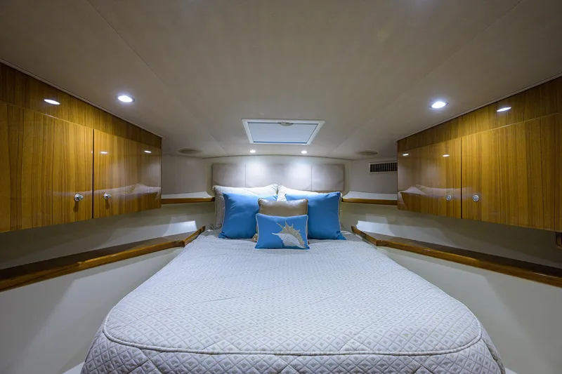 Galene Yacht Photos Pics Luxurious cabin interior of 2013 Viking 42 Open yacht with cozy bedding and wooden cabinets.