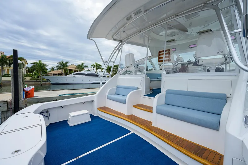 Galene Yacht Photos Pics 2013 Viking 42 Open yacht with blue seating and wooden accents, docked near waterfront homes.