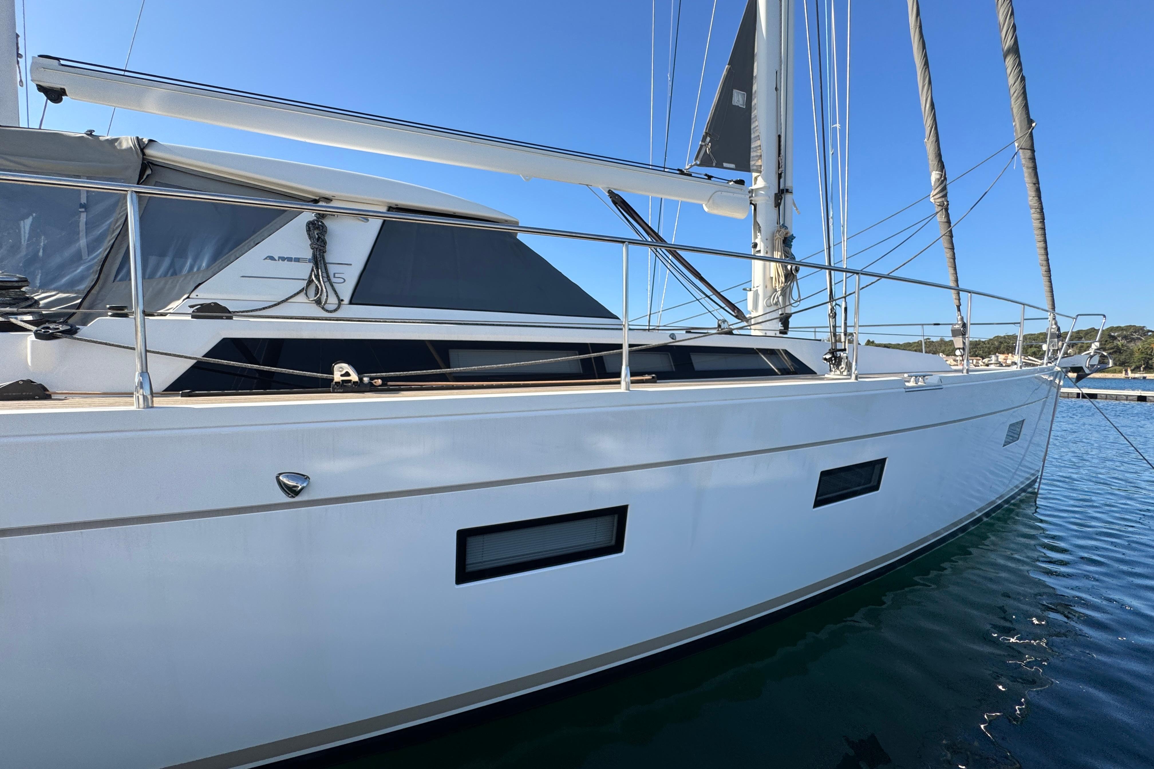Amel 55 yacht, 2015 model, docked in calm waters under clear blue sky.