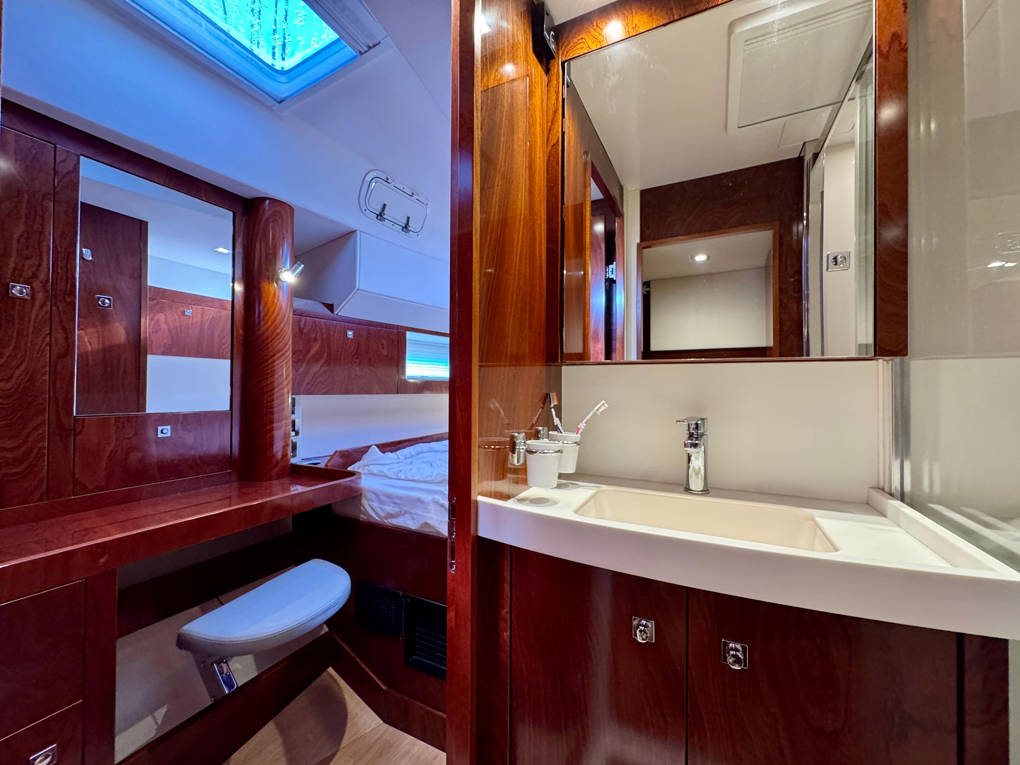Luxurious Amel 55 yacht interior, featuring a modern bathroom and wooden cabinetry, 2015 model.