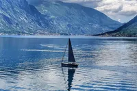 Sailboat Solaris 50 (2019) on serene lake with mountainous backdrop.