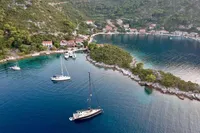 Aerial view of Solaris 50 sailboats in a scenic coastal bay, surrounded by lush greenery.