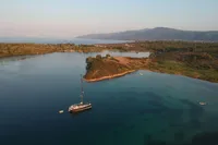 Sailboat Solaris 50 (2019) anchored in serene coastal bay with lush landscape.