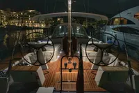 Luxurious 2019 Solaris 50 yacht docked at night, illuminated deck, dual steering wheels.