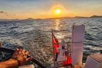 Sailing a 2019 Solaris 50 yacht at sunset, with a scenic ocean view.
