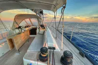 Luxurious 2019 Solaris 50 yacht sailing at sunset on calm ocean waters.