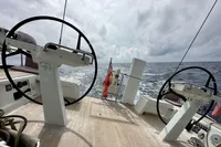 Steering wheels on a 2019 Solaris 50 yacht, sailing on open sea under cloudy skies.