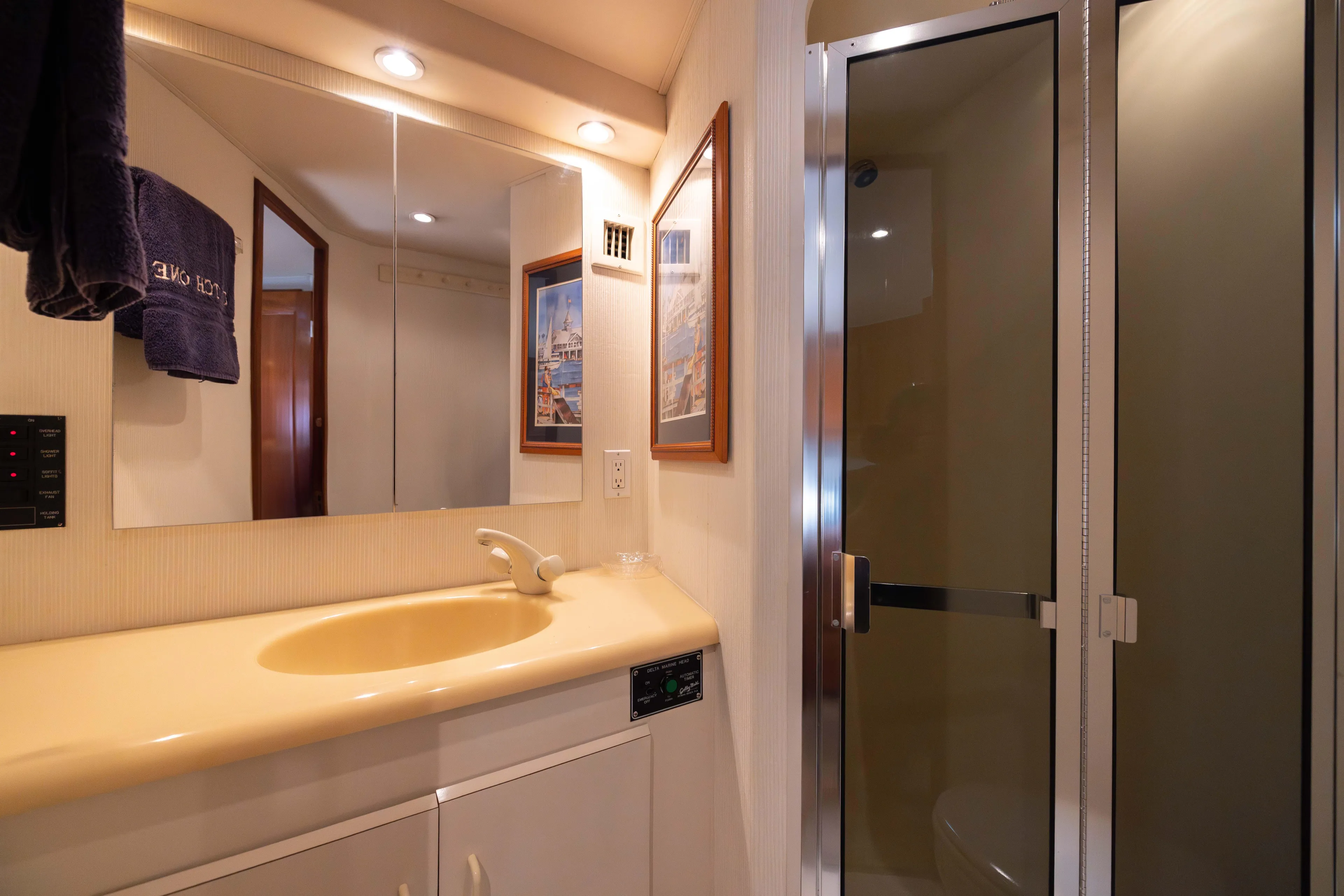 Fan Tail II Yacht Photos Pics 1995 Viking Enclosed Bridge bathroom with yellow sink, mirror, and glass shower door.