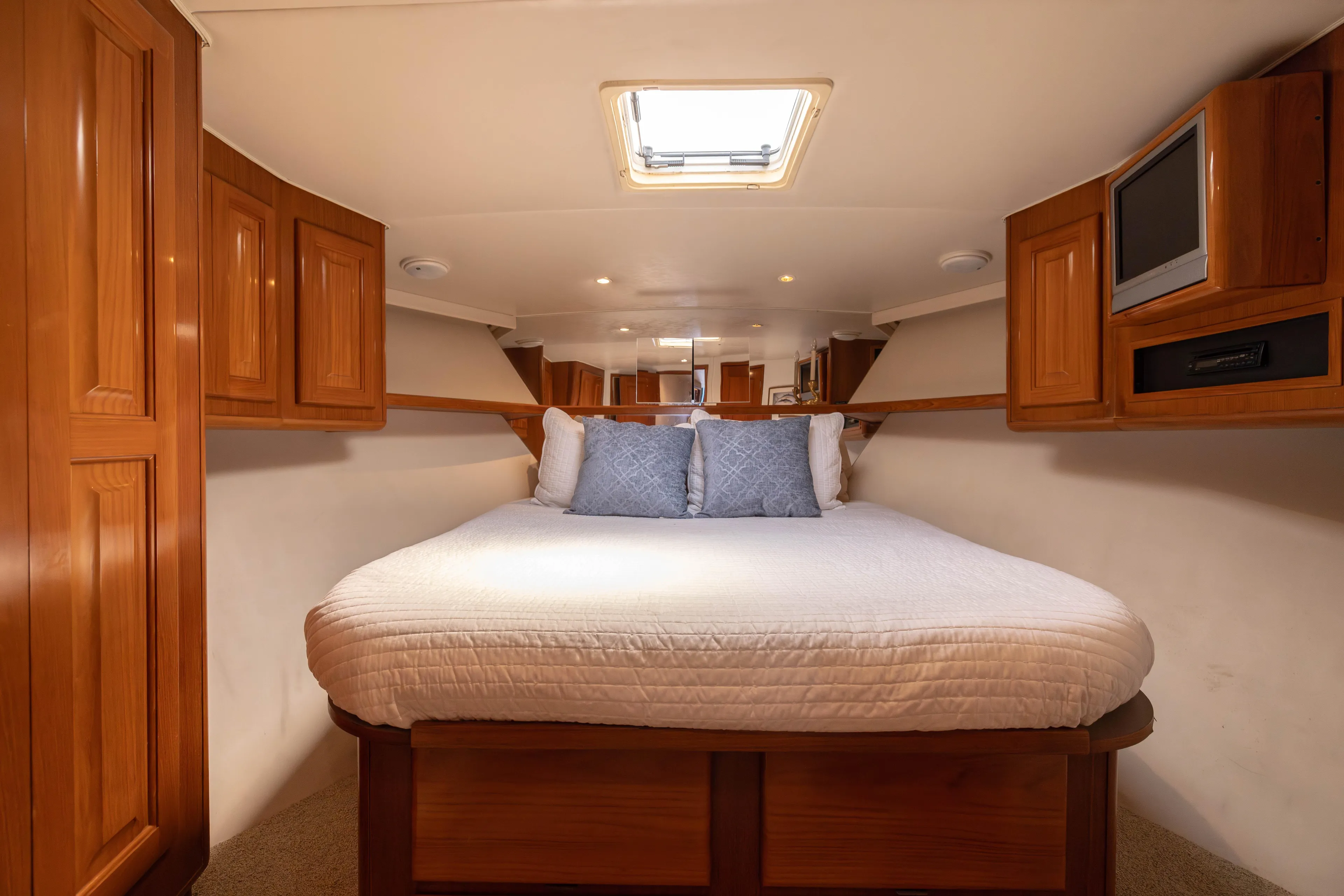 Fan Tail II Yacht Photos Pics Cozy bedroom in 1995 Viking Enclosed Bridge yacht with wood cabinetry and skylight.