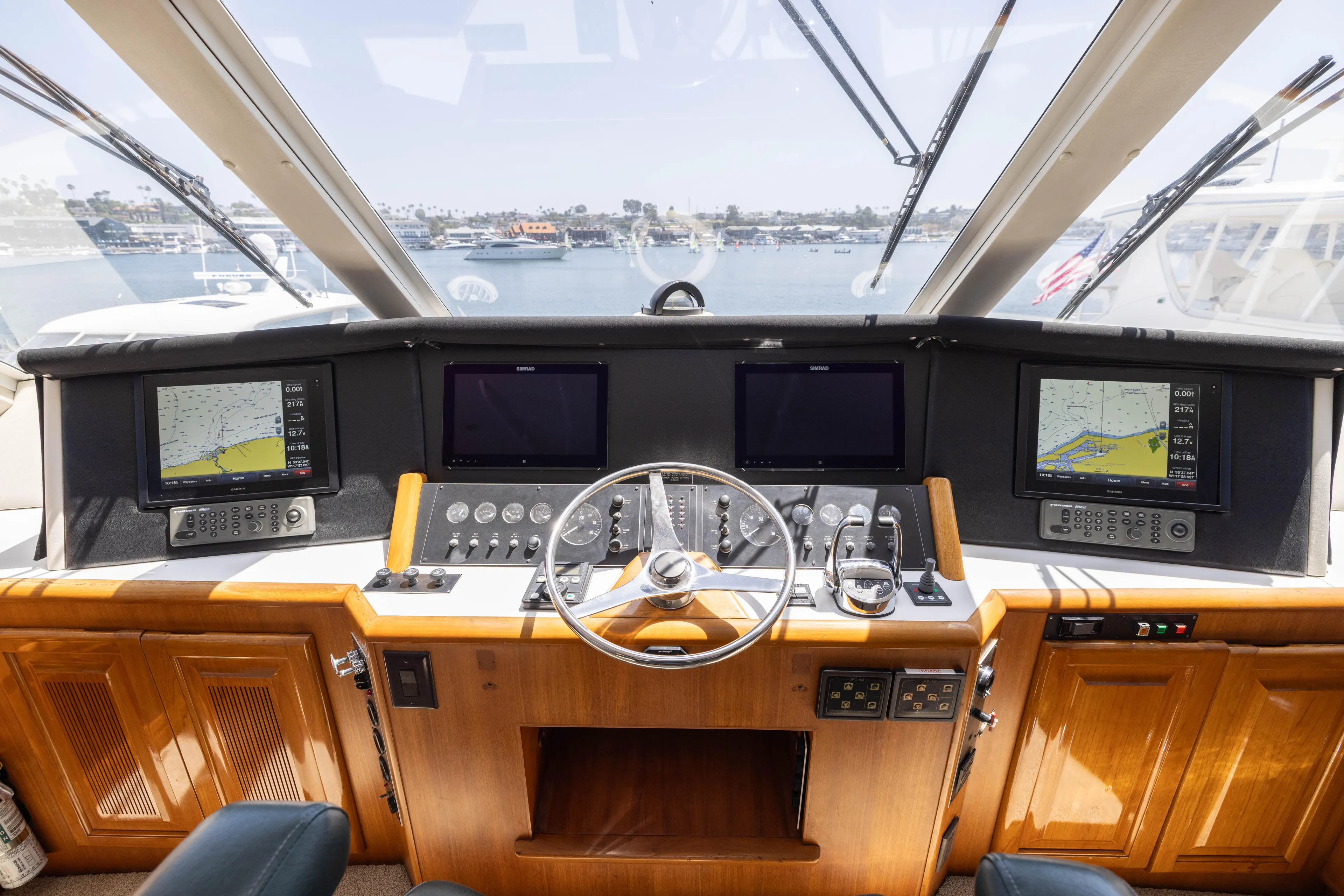 Fan Tail II Yacht Photos Pics 1995 Viking Enclosed Bridge yacht helm with navigation screens and wooden dashboard.