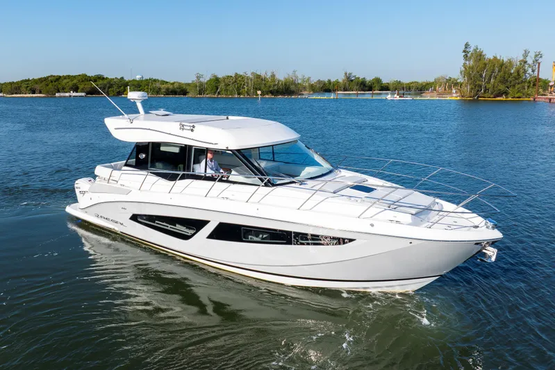 Our Trade Yacht Photos Pics 2024 Regal 42 XO yacht cruising on a serene lake under clear blue skies.