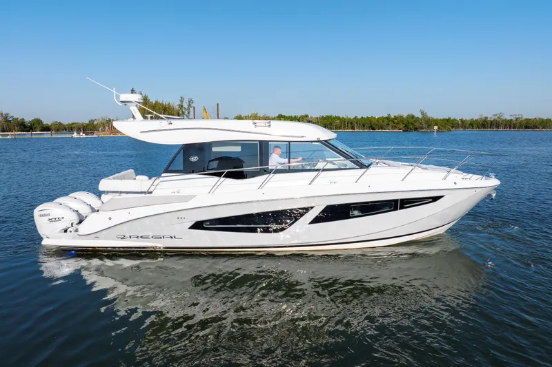 Our Trade Yacht Photos Pics 2024 Regal 42 XO luxury yacht cruising on a serene lake.