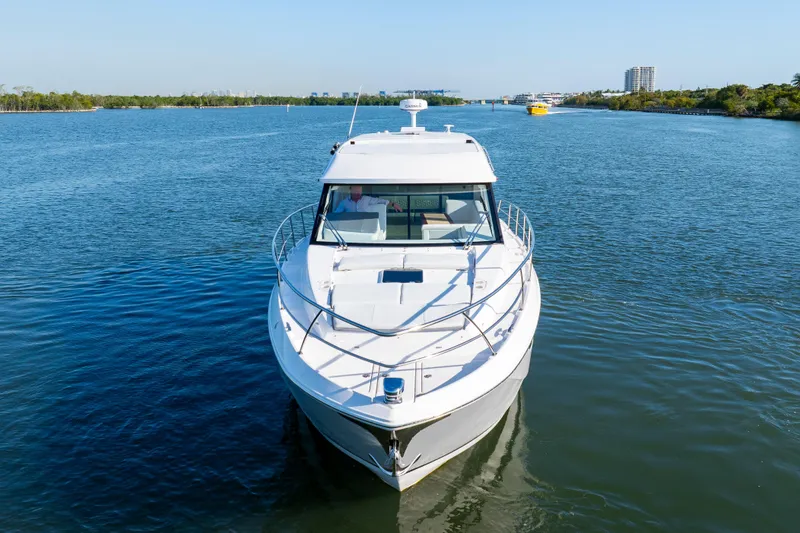 Our Trade Yacht Photos Pics 2024 Regal 42 XO yacht cruising on a serene river with clear blue skies.