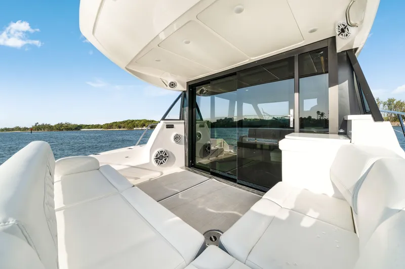 Our Trade Yacht Photos Pics Luxurious 2024 Regal 42 XO yacht interior with white seating and scenic water view.