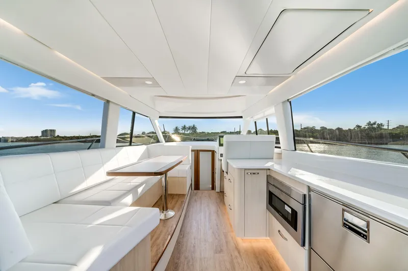 Our Trade Yacht Photos Pics Luxurious interior of 2024 Regal 42 XO yacht with modern kitchen and seating area.