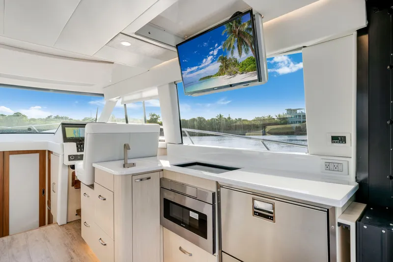 Our Trade Yacht Photos Pics Luxurious interior of 2024 Regal 42 XO yacht with modern kitchen and scenic view.
