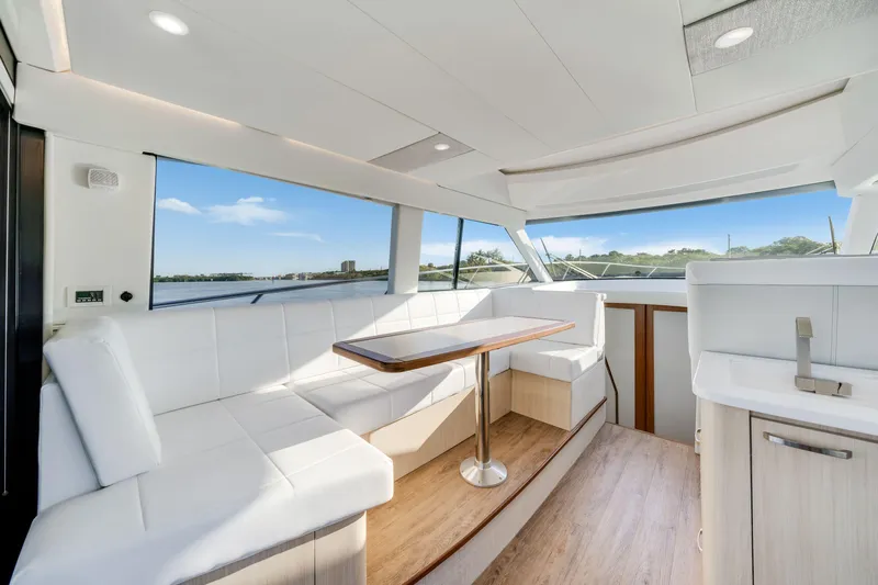 Our Trade Yacht Photos Pics Luxurious interior of 2024 Regal 42 XO yacht with white seating and panoramic windows.