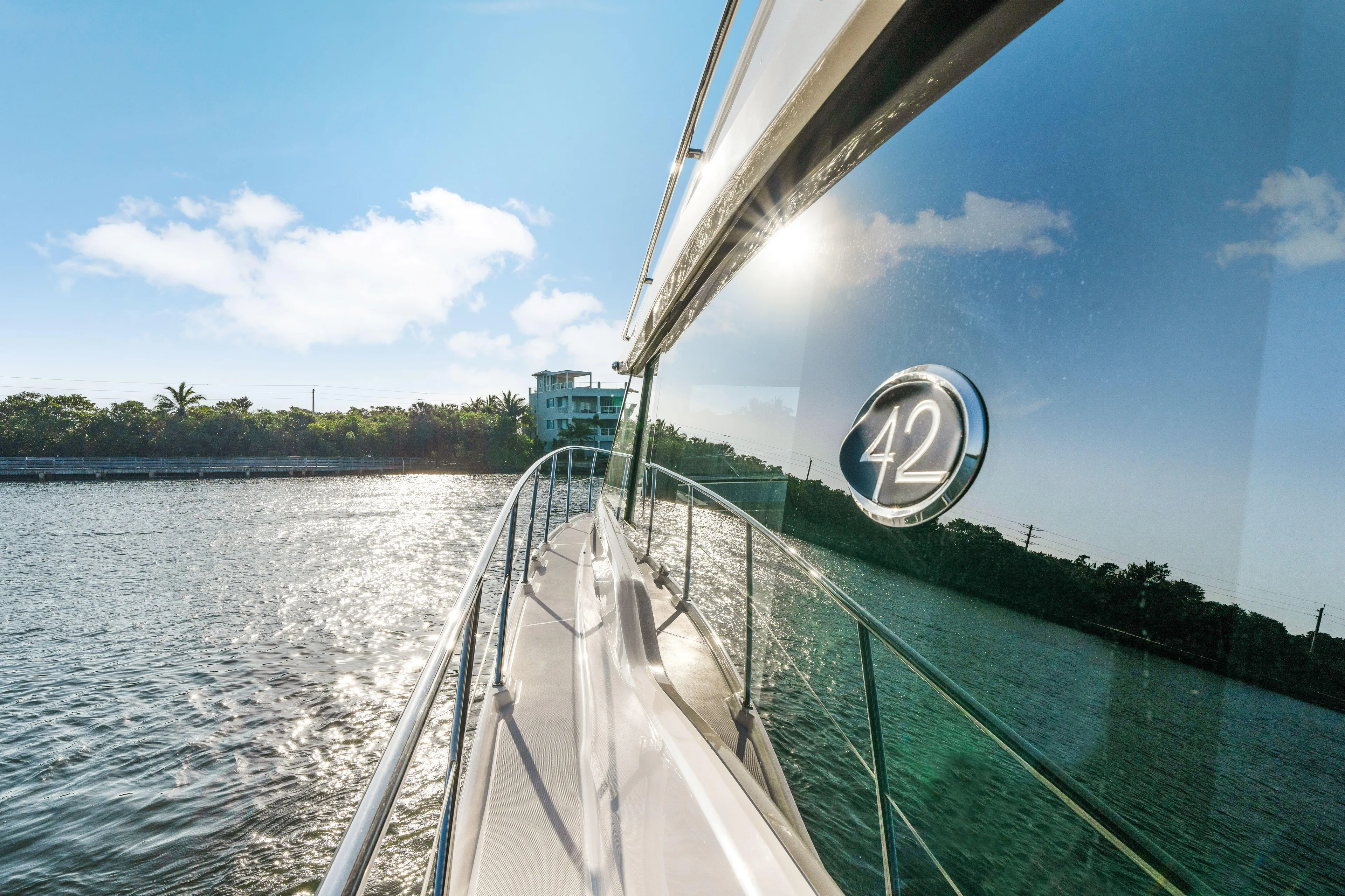 Our Trade Yacht Photos Pics 2024 Regal 42 XO yacht cruising on a sunny day, reflecting water and sky.