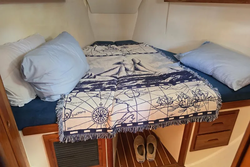Sail Fourth Yacht Photos Pics Cozy cabin bed in 2001 Tartan 3700 sailboat with nautical-themed blanket.