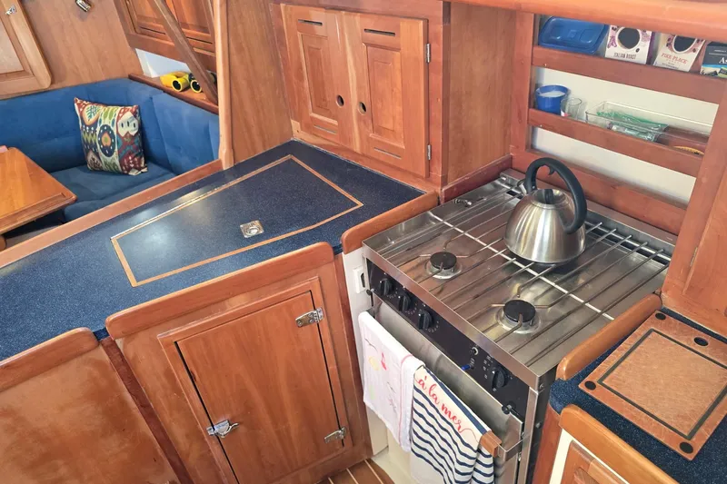 Sail Fourth Yacht Photos Pics Cozy Tartan 3700 yacht kitchen with wooden cabinets and stainless steel stove, 2001 model.