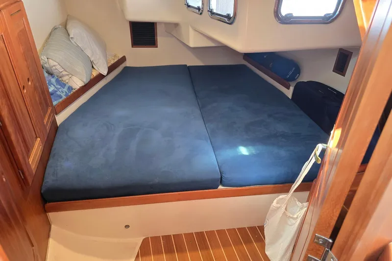 Sail Fourth Yacht Photos Pics Cozy cabin interior of 2001 Tartan 3700 sailboat with blue bedding and wooden accents.