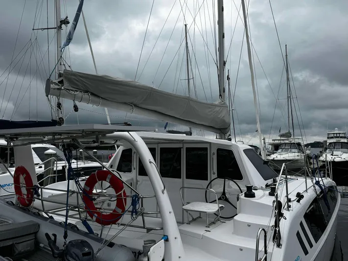Shared Adventure Yacht Photos Pics 2023 Seawind 1160 Lite catamaran docked at marina under cloudy sky.
