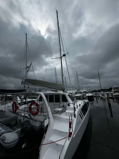 Shared Adventure Yacht Photos Pics 2023 Seawind 1160 Lite catamaran docked at a marina under cloudy skies.
