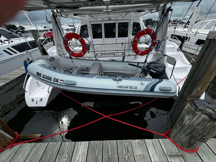 Shared Adventure Yacht Photos Pics Seawind 1160 Lite 2023 catamaran with a Highfield dinghy docked at a marina.