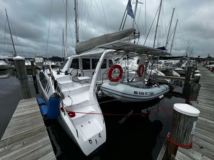Shared Adventure Yacht Photos Pics 2023 Seawind 1160 Lite catamaran docked at marina with dinghy.