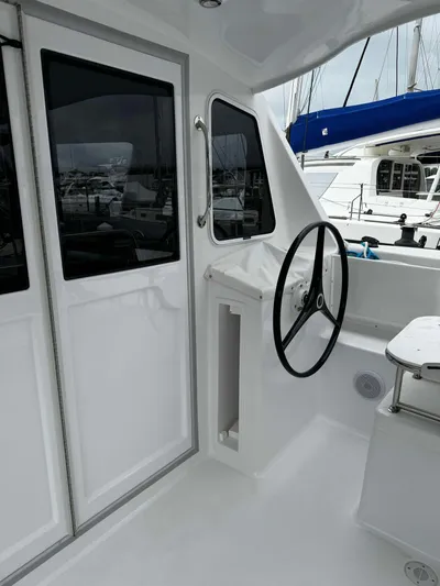 Shared Adventure Yacht Photos Pics 2023 Seawind 1160 Lite yacht cockpit with steering wheel and windows.