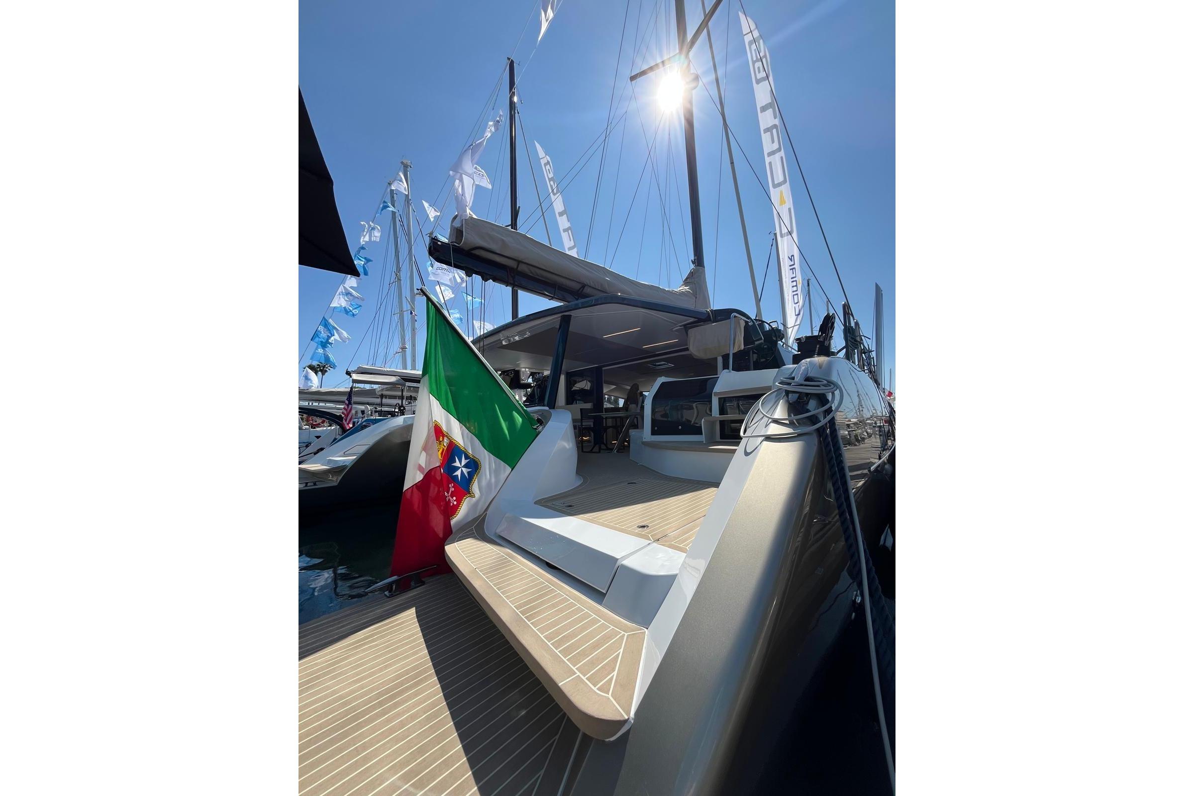 2026 Comar C-CAT 65 catamaran docked, featuring sleek design and Italian flag.