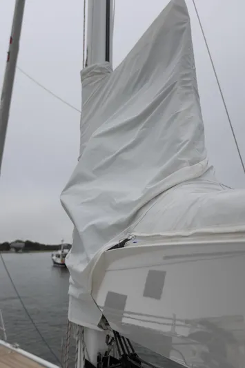 *previous Name Reserved Yacht Photos Pics 2019 Nautor Swan 48 sailboat with covered mast, docked on a cloudy day.
