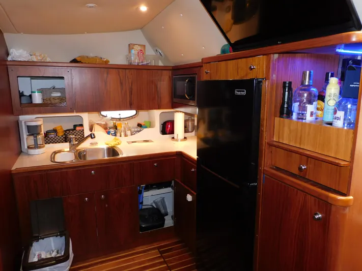 Mad Hatter Yacht Photos Pics 1997 Tiara Yachts Open kitchen with wood cabinets, sink, and appliances.