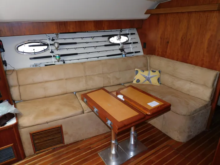 Mad Hatter Yacht Photos Pics Cozy interior of 1997 Tiara Yachts Open with beige seating and wooden table.