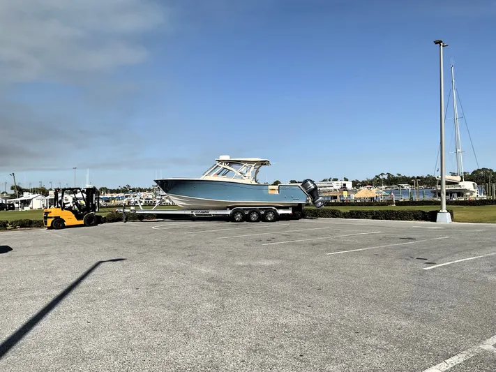  Yacht Photos Pics 2021 Grady-White Freedom 307 boat on trailer in parking lot, clear sky background.