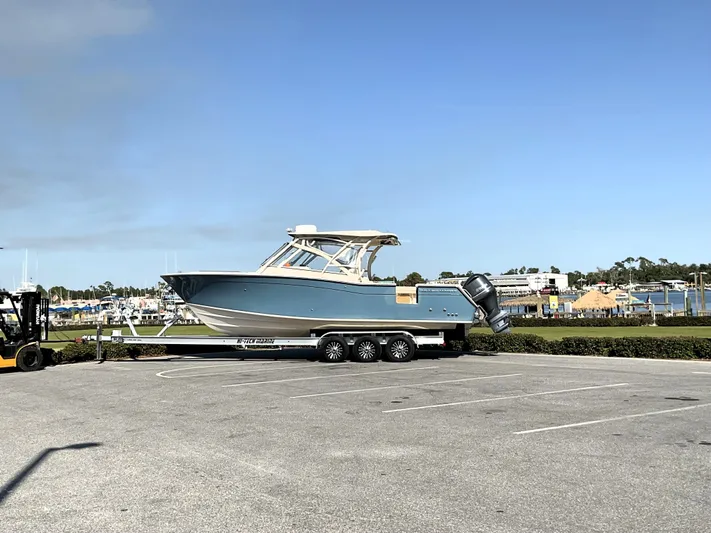  Yacht Photos Pics 2021 Grady-White Freedom 307 boat on trailer in parking lot, clear sky background.