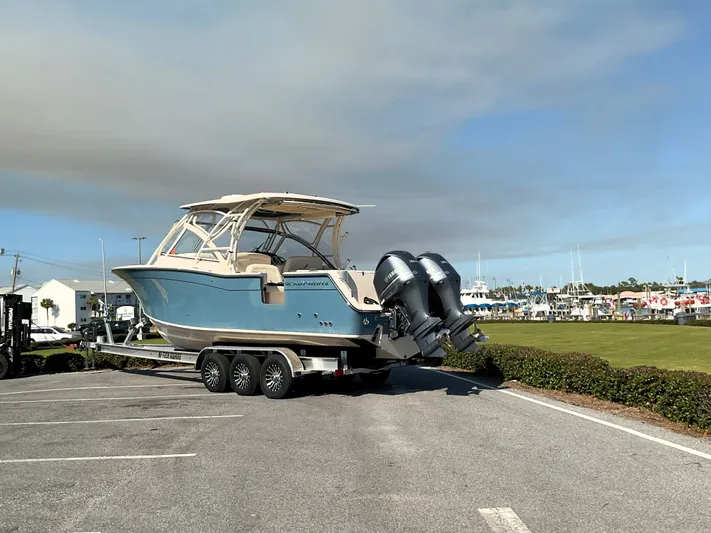  Yacht Photos Pics 2021 Grady-White Freedom 307 boat on trailer in parking lot, clear sky background.