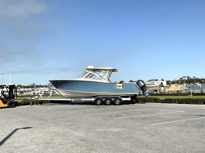  Yacht Photos Pics 2021 Grady-White Freedom 307 boat on trailer in parking lot, clear sky background.