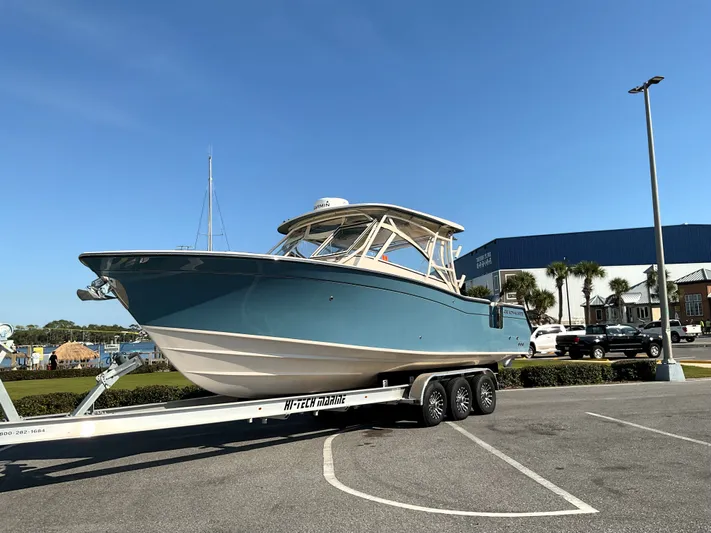  Yacht Photos Pics 2021 Grady-White Freedom 307 boat on trailer in parking lot, clear blue sky.
