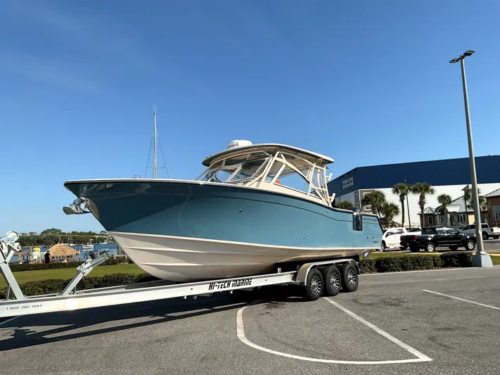 Yacht Photos Pics 2021 Grady-White Freedom 307 boat on trailer in parking lot under clear blue sky.