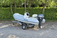 2022 AB Inflatables 11 ALX boat with Yamaha motor on trailer, parked outdoors.