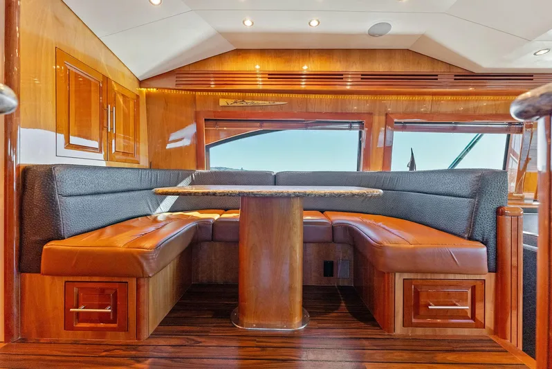 Chupacabra Yacht Photos Pics Luxurious interior of a 2007 Hatteras 64 Convertible yacht with wooden finishes and leather seating.