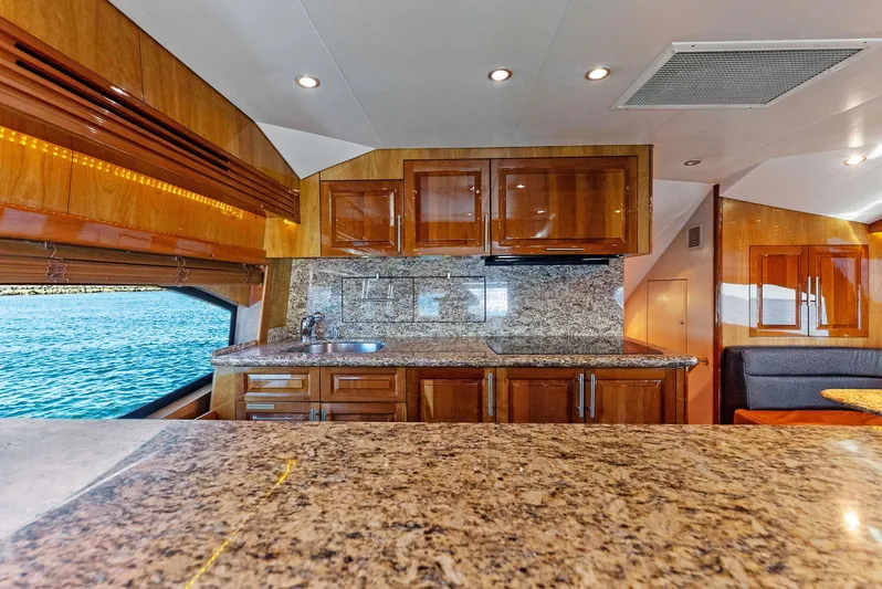 Chupacabra Yacht Photos Pics Luxurious kitchen interior of 2007 Hatteras 64 Convertible yacht with granite countertops.