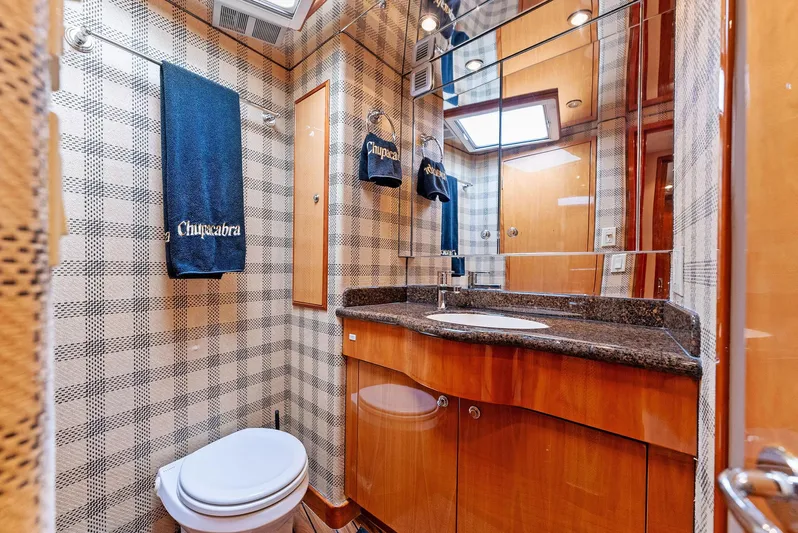 Chupacabra Yacht Photos Pics Luxurious bathroom in 2007 Hatteras 64 Convertible yacht with wood cabinetry and granite countertop.